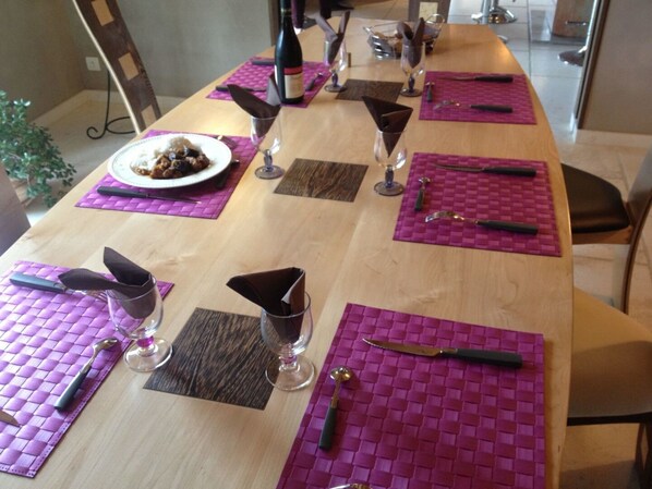 A dining table set with purple placemats, wine glasses, and cutlery. - Millygite - Forêt Fontainebleau (Milly-la-Foret)