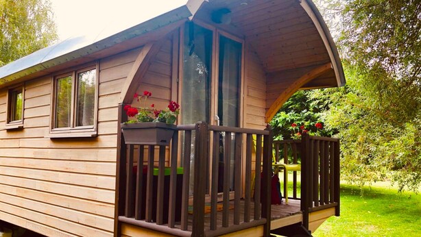 Eine Holzhütte mit Veranda, Fenstern und einem Schild mit der Aufschrift 'Guyton'.