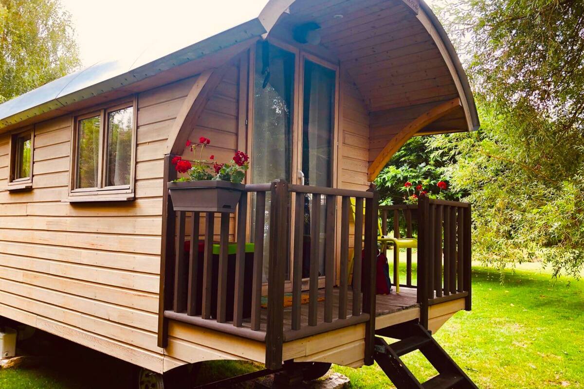 Une cabane en bois avec une véranda, des fenêtres et une enseigne sur laquelle on peut lire « Guyton ».