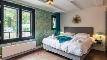 Ein Schlafzimmer mit einem Bett, einem Fenster, einer Wandleuchte und einem Wanddekor.