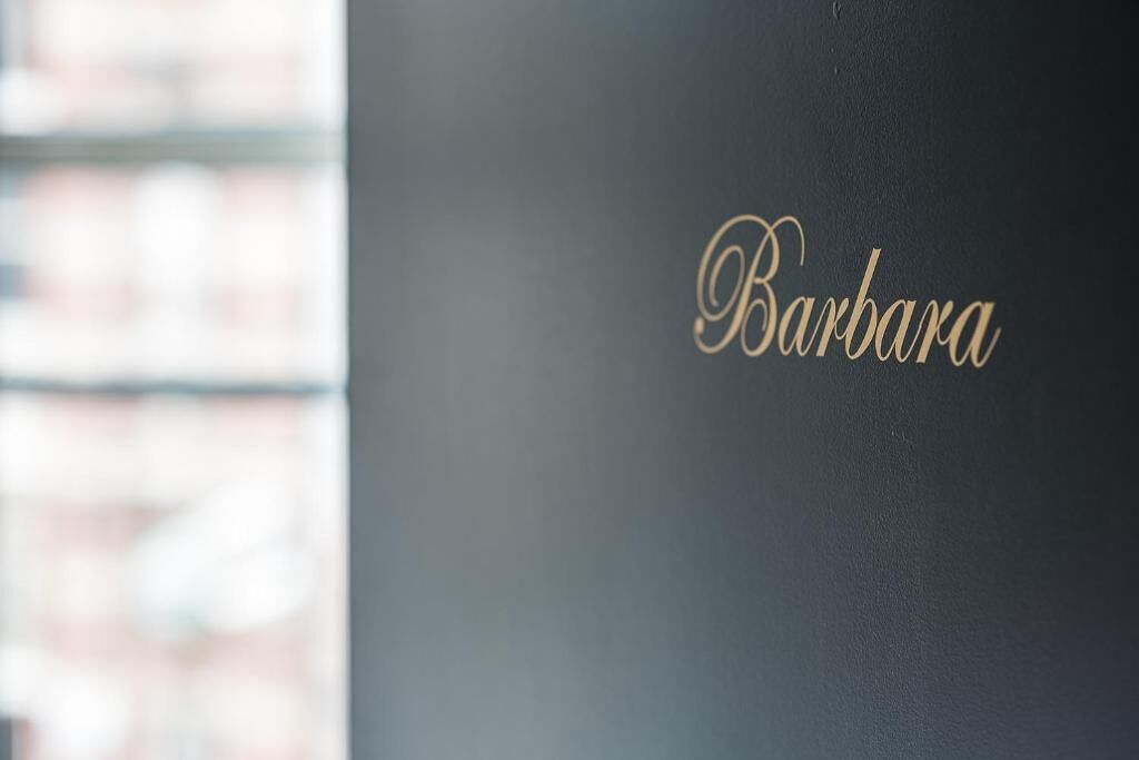 Paredes com o nome "Barbara" em dourado cursivo.