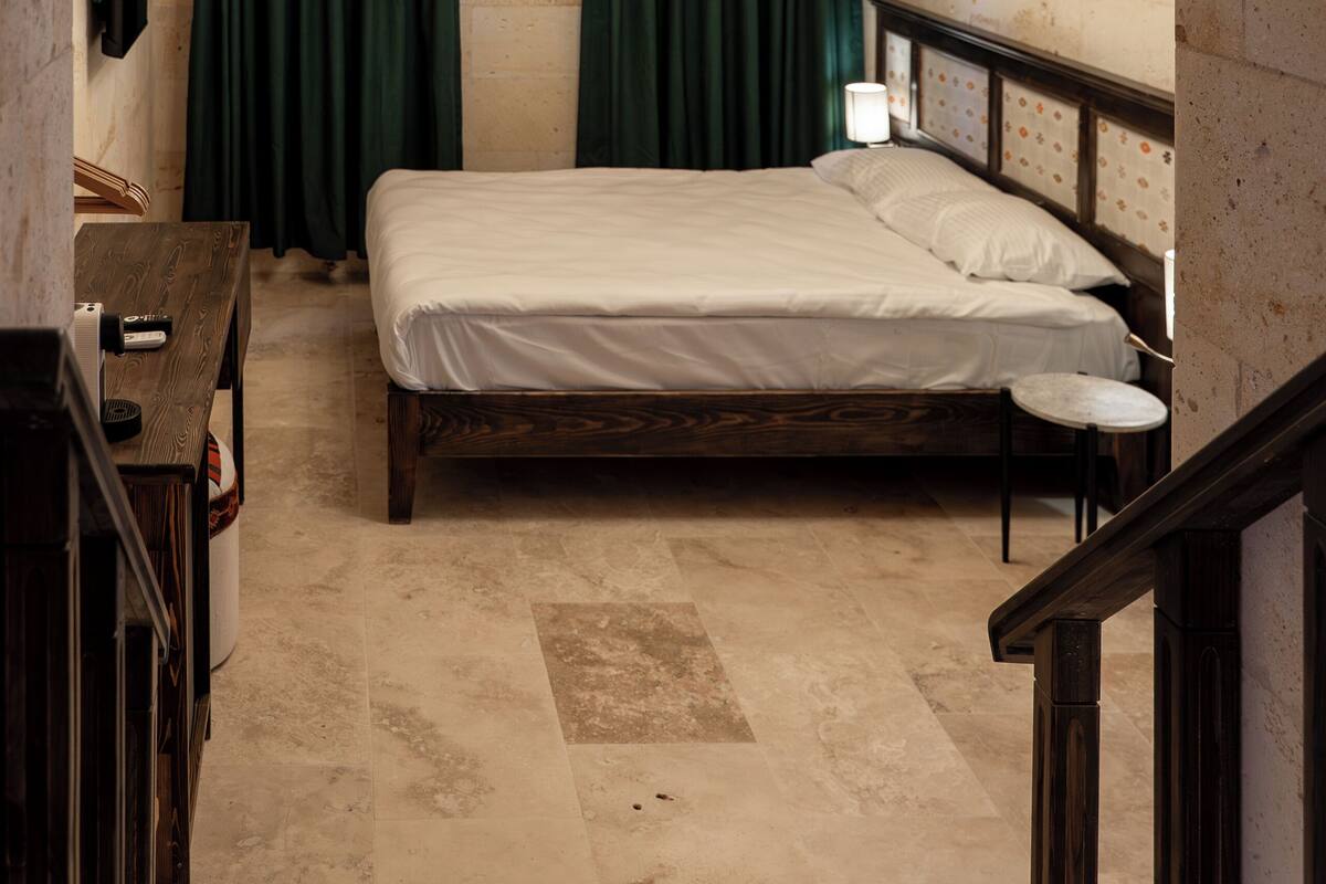 Una habitación con una cama, un escritorio y una araña.