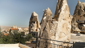 Blick auf Felsformationen und traditionelle Architektur, vermutlich Teil einer historischen Stätte oder Touristenattraktion.