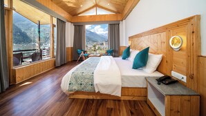 Un dormitorio con paneles de madera, una cama grande, una mesita de noche y vistas a un paisaje montañoso.