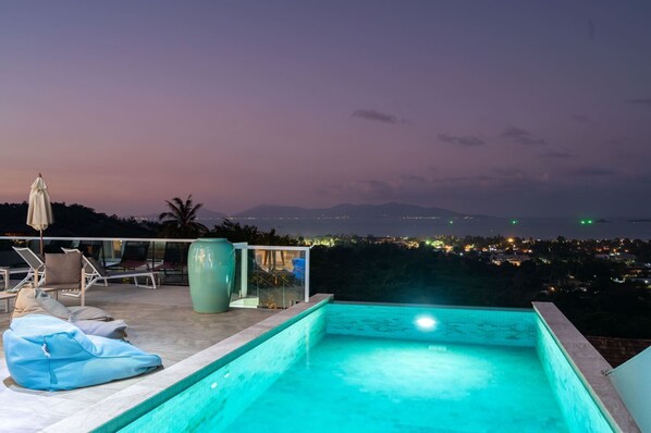 Una piscina al aire libre, sombrillas, tumbonas
