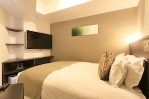 A hotel room with a bed, a flat-screen TV mounted on the wall, a bedside table, and a small shelf. - Centurion Hotel Ikebukuro Station (Tokyo)