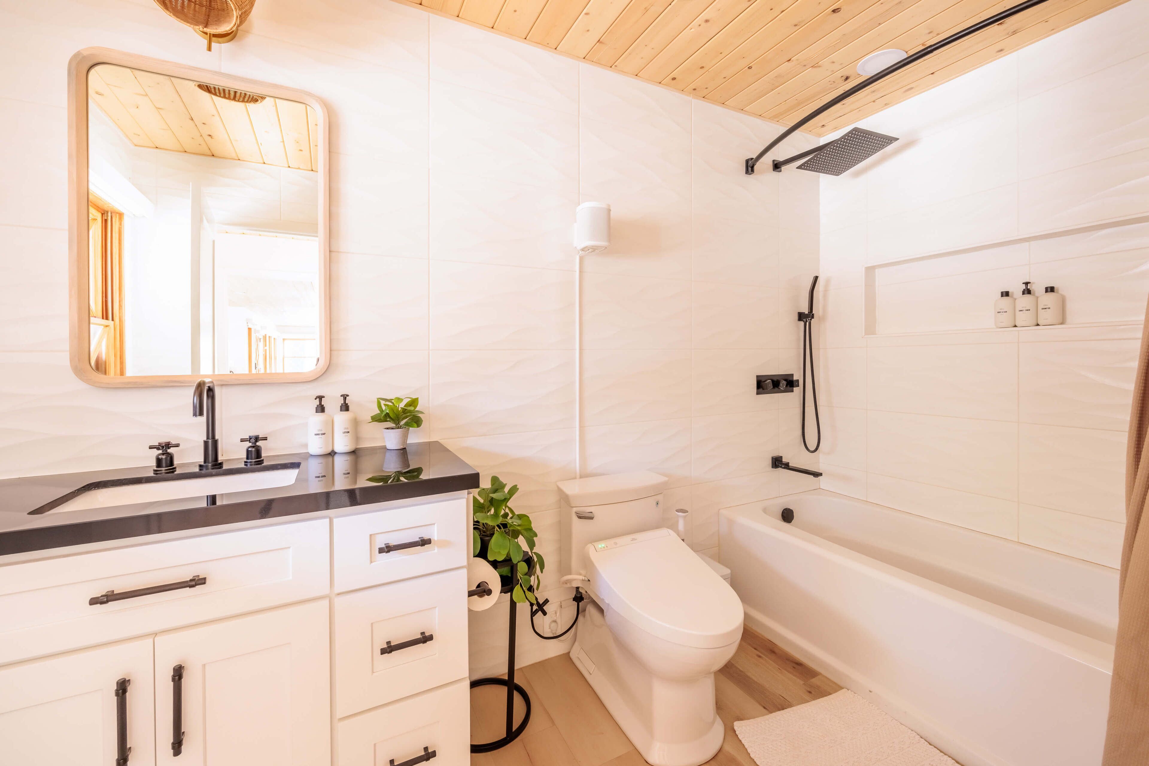 A modern bathroom with a sink, toilet, and bathtub.