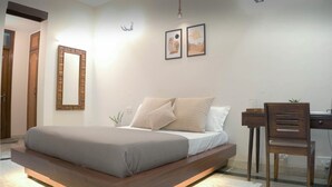 Un dormitorio moderno con cama, escritorio y silla.