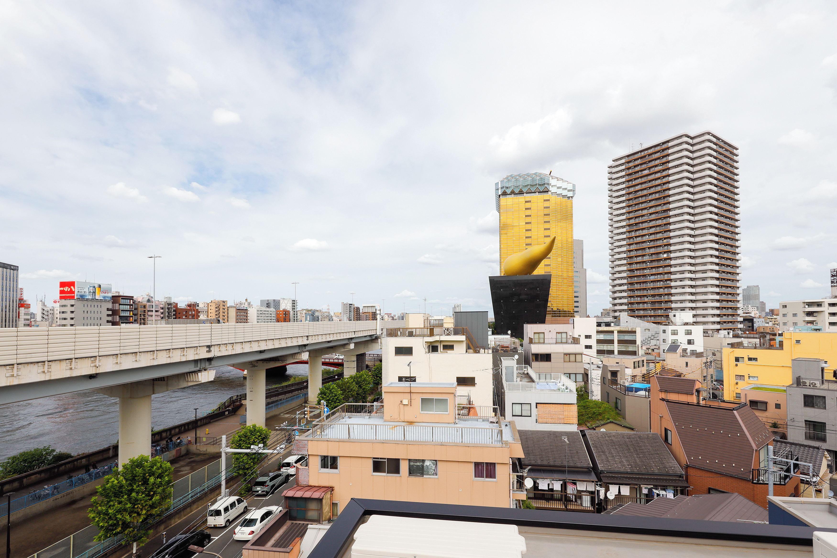 Une vue urbaine avec un bâtiment jaune imposant, un pont et une rivière.