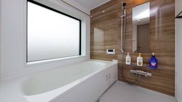 Bañera con ducha, secador de pelo, pantuflas, toallas