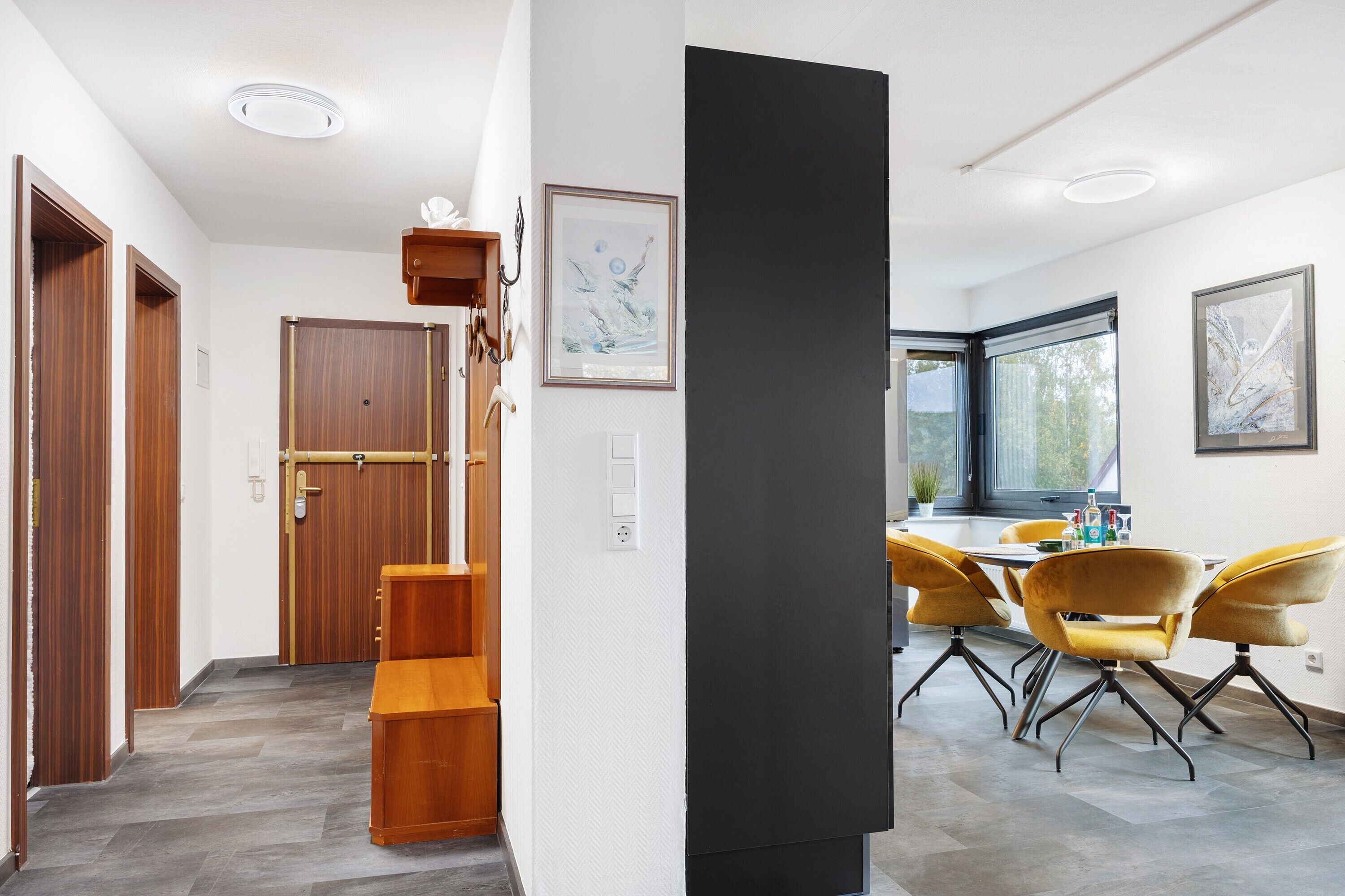 Ein modernes Interieur mit Essbereich, Holztüren und einer Treppe.