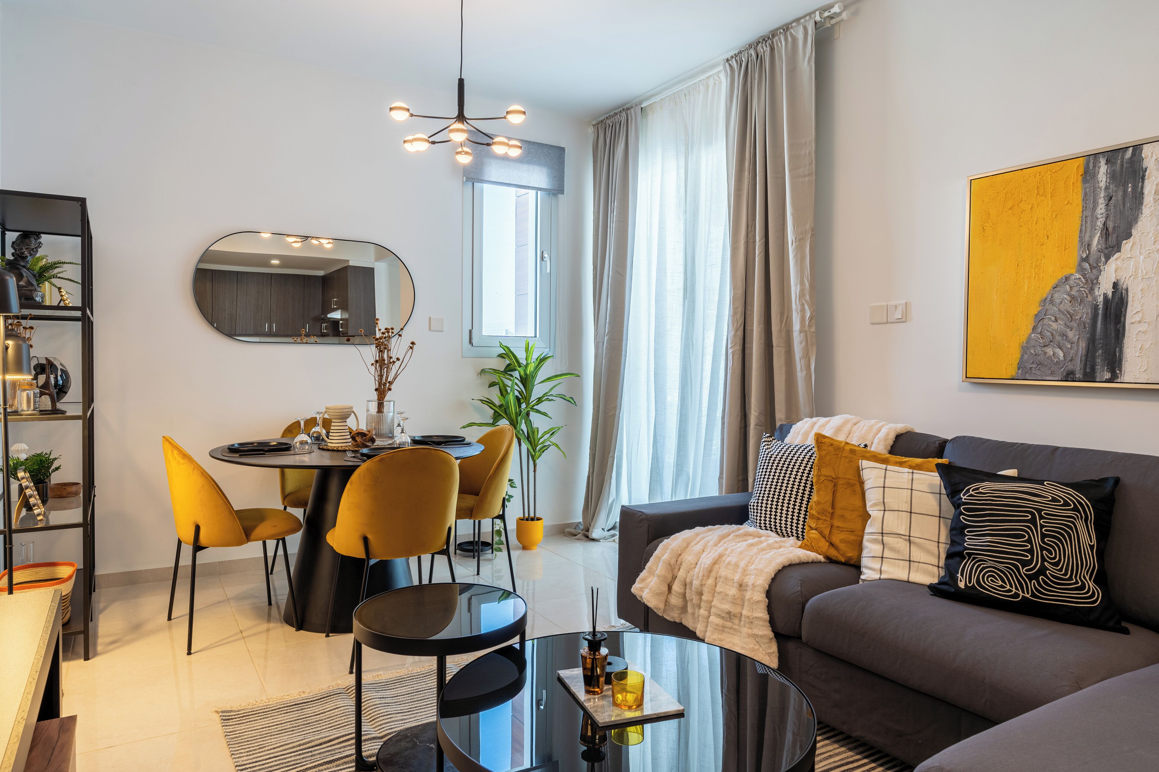 Ein modernes Wohnzimmer mit einer Couch, einem Couchtisch und einem Essbereich mit Stühlen und einem Tisch.