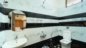 Une salle de bain avec un lavabo, des toilettes et une douche.