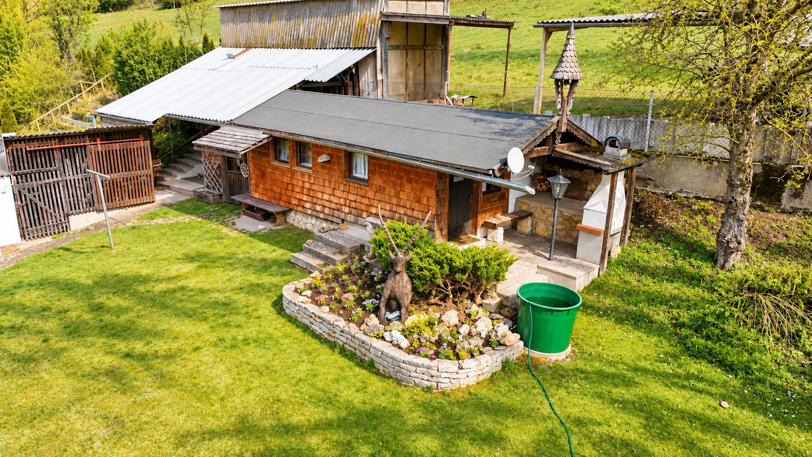 Una casa rústica con base de piedra, revestimiento de madera y techo de metal.