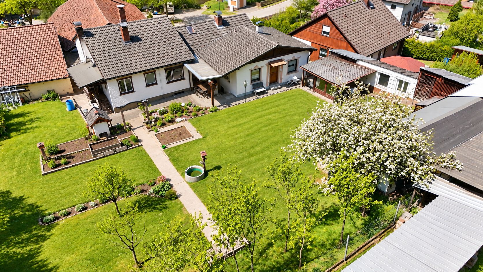 Eine Wohngegend mit mehreren Häusern, einem gepflegten Rasen und einer kleinen Gartenanlage.
