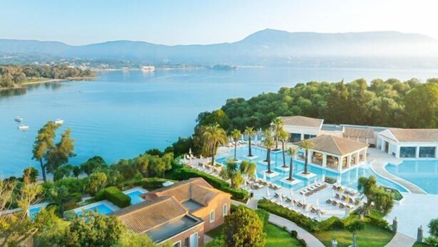 A resort with multiple swimming pools, a large lake, and surrounding greenery. - Grecotel Eva Palace (Limni)