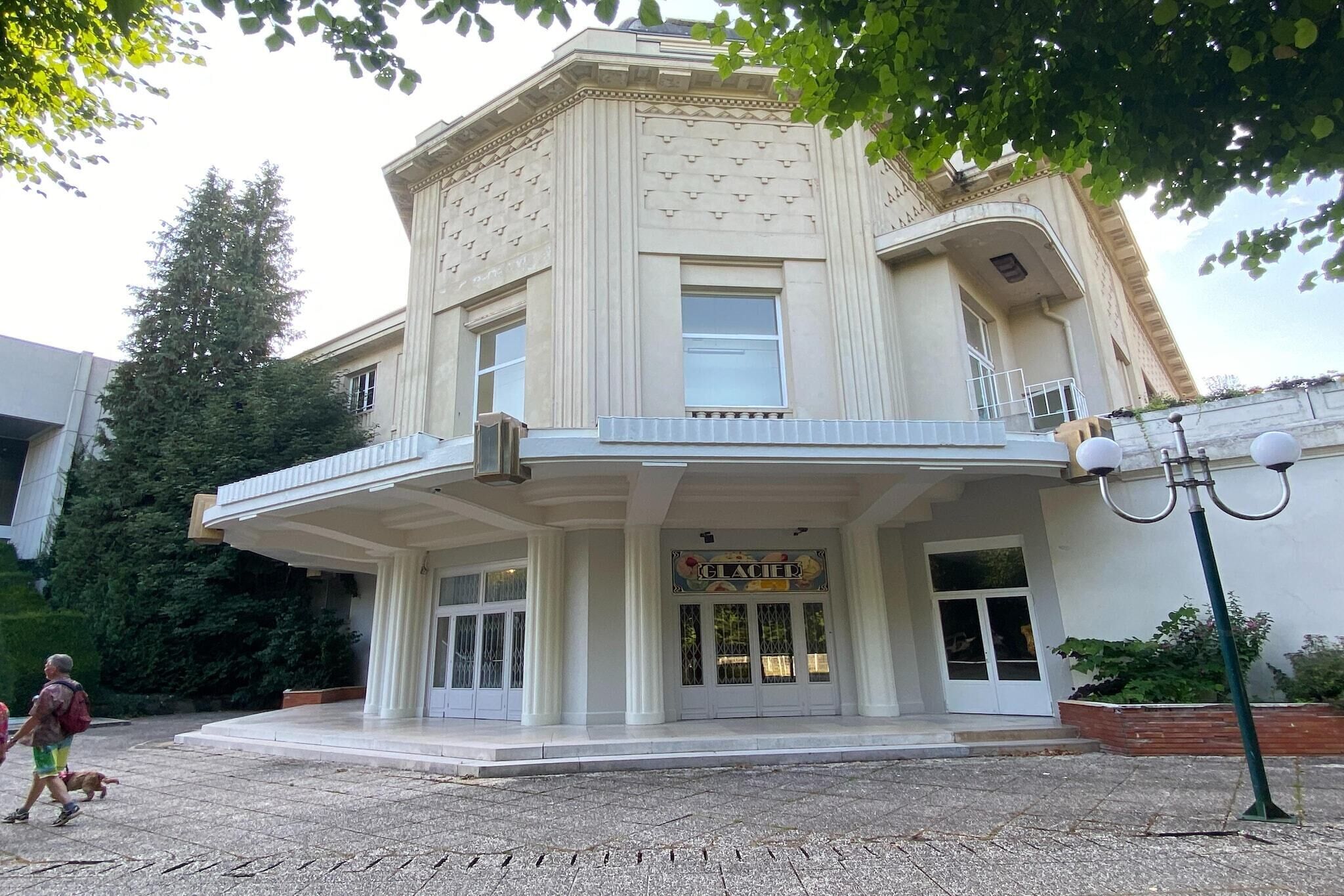 Un bâtiment de style architectural classique, doté d’une entrée imposante avec un balcon et d’une enseigne sur laquelle on peut lire « KELAFED ».