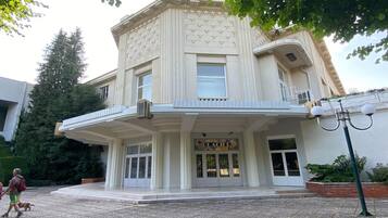 Un bâtiment de style architectural classique, doté d’une entrée imposante avec un balcon et d’une enseigne sur laquelle on peut lire « KELAFED ».