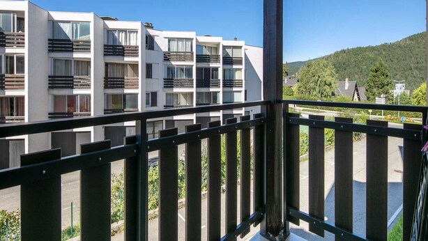 A multi-story building with balconies, a clear sky, and a hilly landscape in the background. - Mountain hideaway in Villard de Lans (Villard-de-Lans)