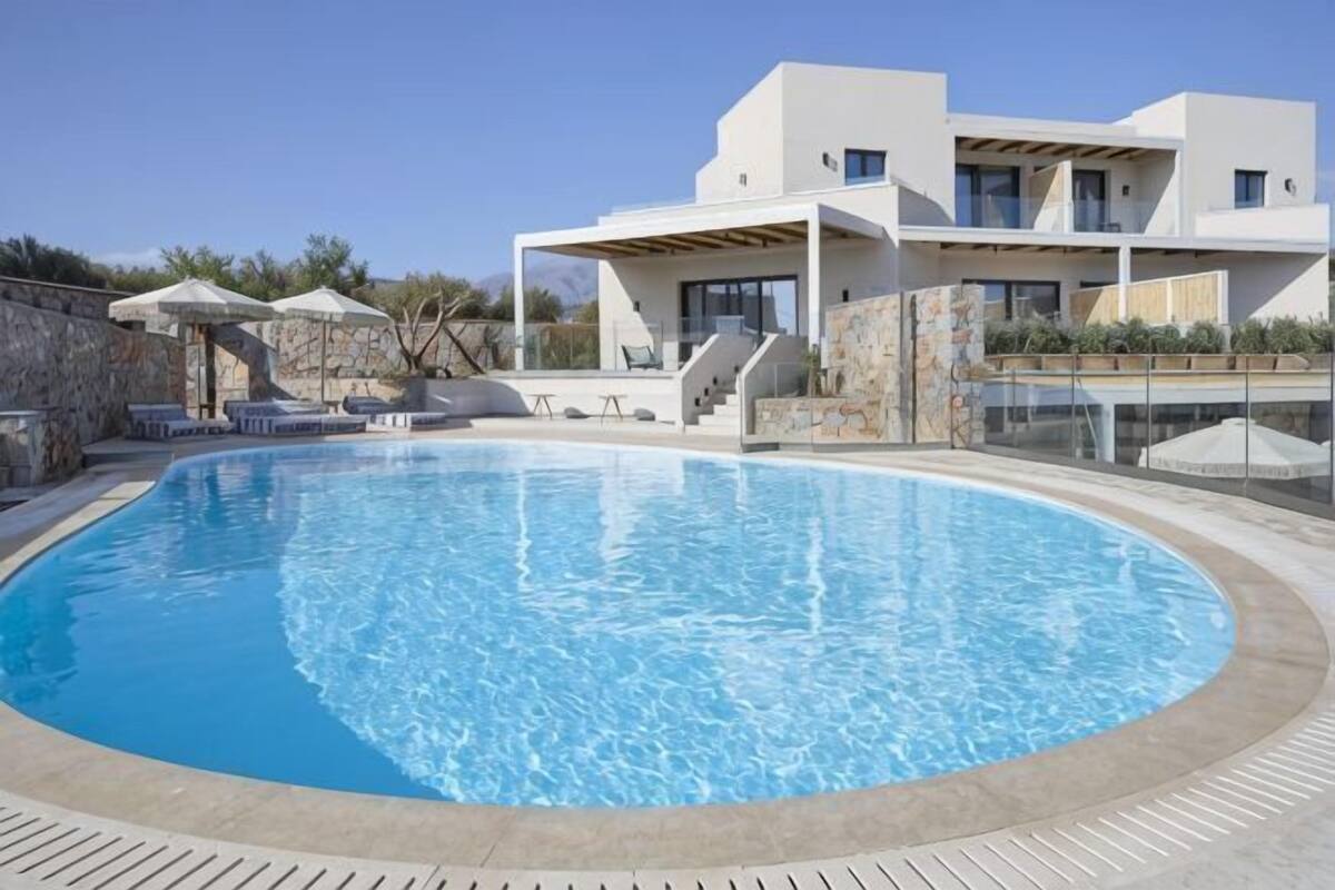 A swimming pool with a modern house in the background.