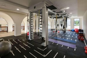 A gym with a pull-up bar, exercise balls, and weight plates. - Wyndham Grand Crete Mirabello Bay (Agios Nikolaos)