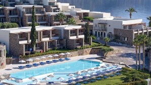 Un complexe hôtelier doté d’une piscine, de plusieurs balcons et offrant une vue sur la mer.