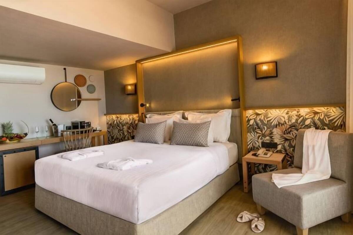 A modern hotel room with a large bed, bedside tables, a desk, and a chair.