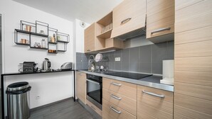 A modern kitchen with wooden cabinets, a stainless steel countertop, and a built-in oven. - Family-friendly apartment with terrace (Allos)