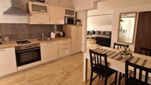 A modern kitchen with a dining area. It includes a stove, microwave, sink, and cabinets.