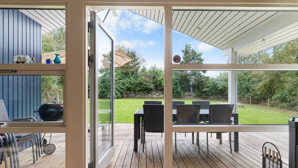 Eine moderne Außenterrasse mit Glastür zu einem Patio-Bereich.