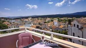 Ein Balkon mit einem Schild mit der Aufschrift 'Welcome', einem Stuhl und einem Vogelkäfig.