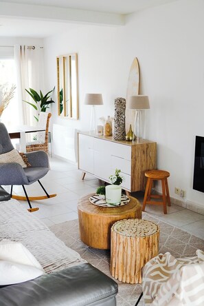 A modern living room with a grey sofa, a wooden coffee table, and a white cabinet.