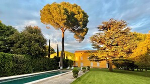 A pool with a grassy area and a building with a yellow facade. - The LumiPod Suite - Haras de Castellane - Swimming pool - In the heart of Provence (Pertuis)