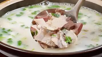Un tazón de sopa con carne y hierbas.