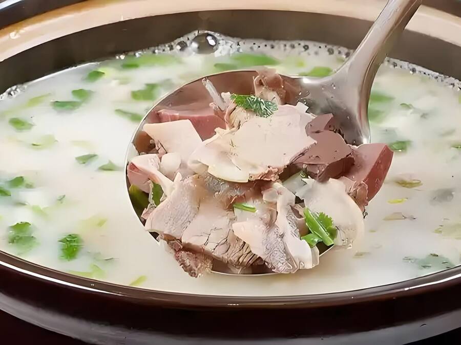 Un tazón de sopa con carne y hierbas.
