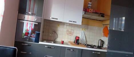 A kitchen with a gas stove, oven, and cabinets.