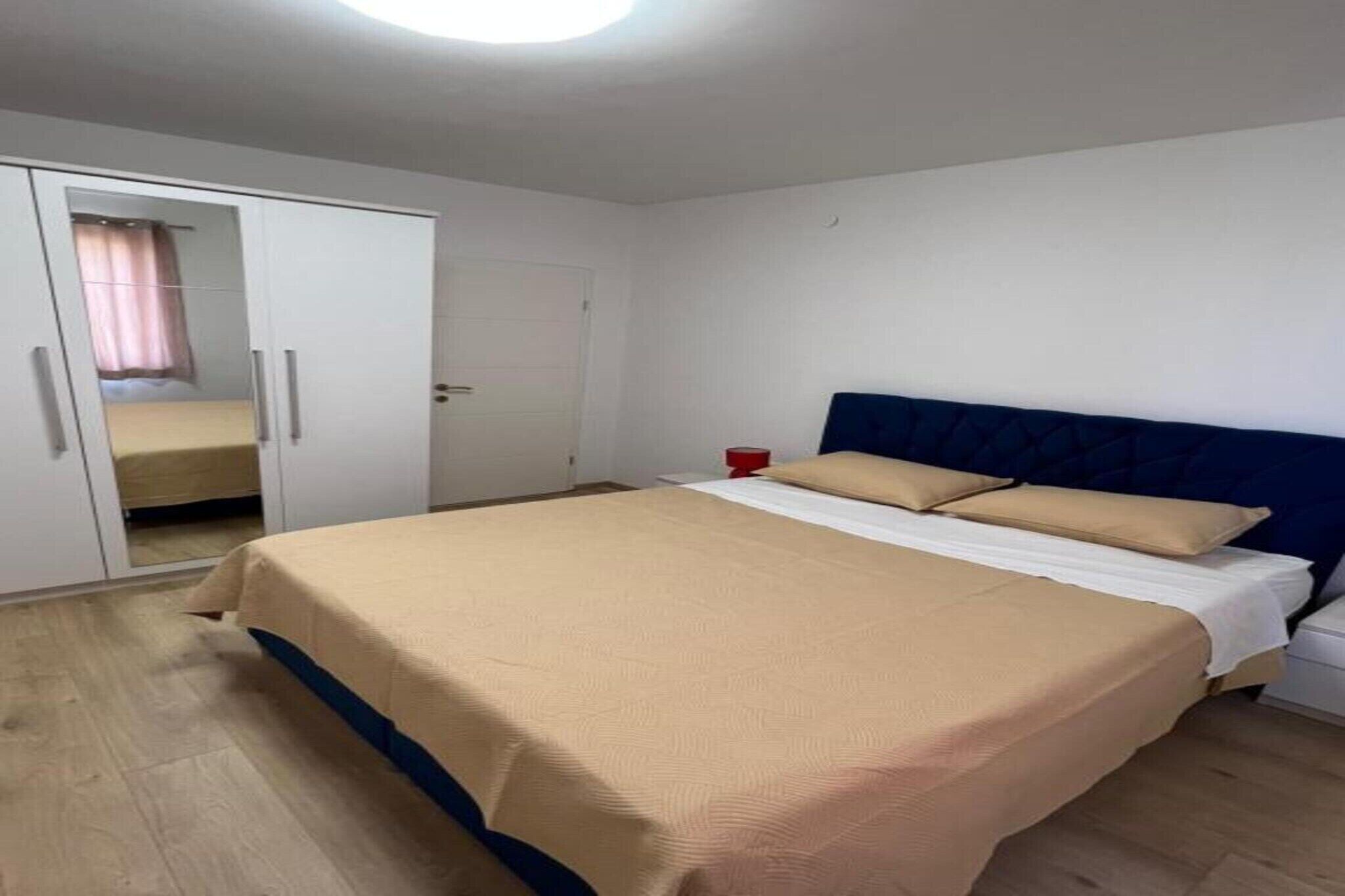 Une chambre à coucher avec un lit, une armoire et une table de chevet.