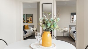 Une chambre d’hôtel avec un lit, une table de chevet, une commode, un miroir et une fenêtre.