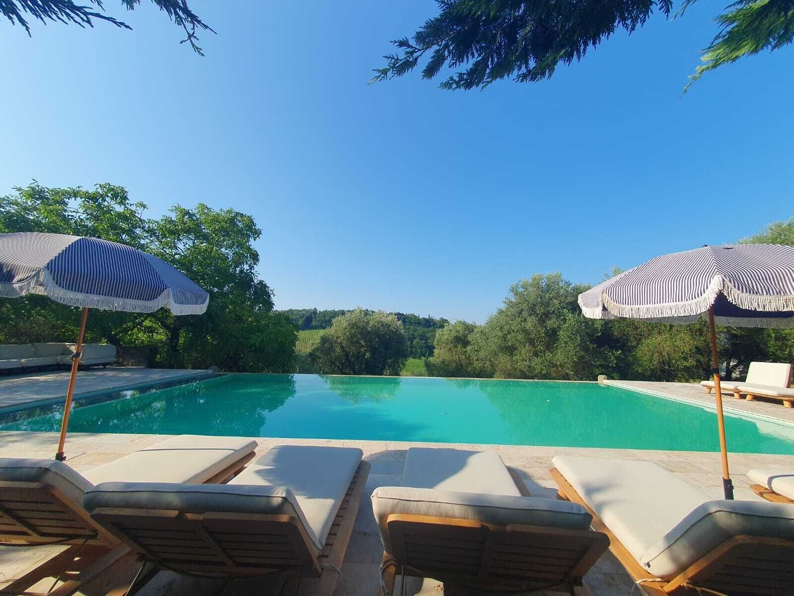 Alberca al aire libre, sombrillas en la alberca y camastros 