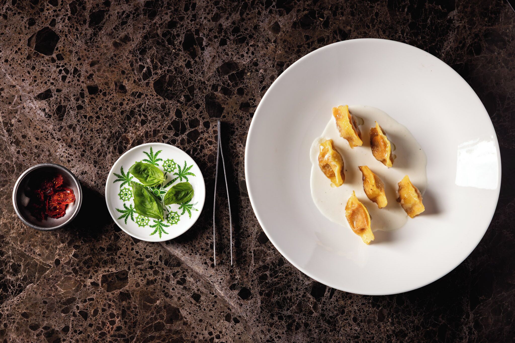 A white plate with food on a dark marble surface.