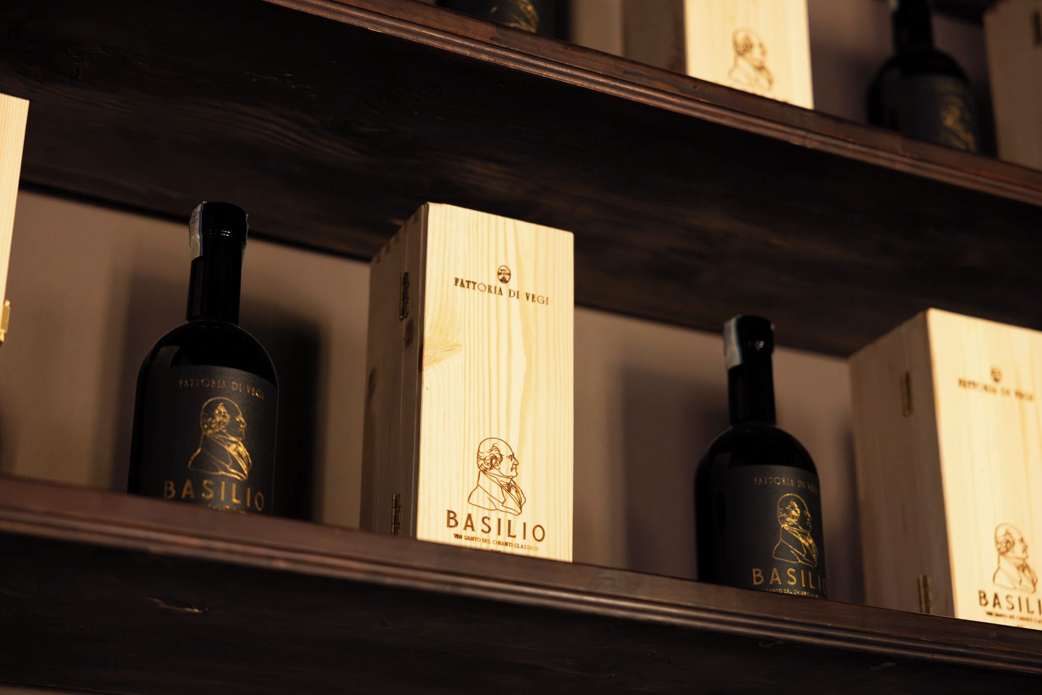 A shelf with bottles and boxes labeled 'Basilio' and 'Fattoria di Vegi.'