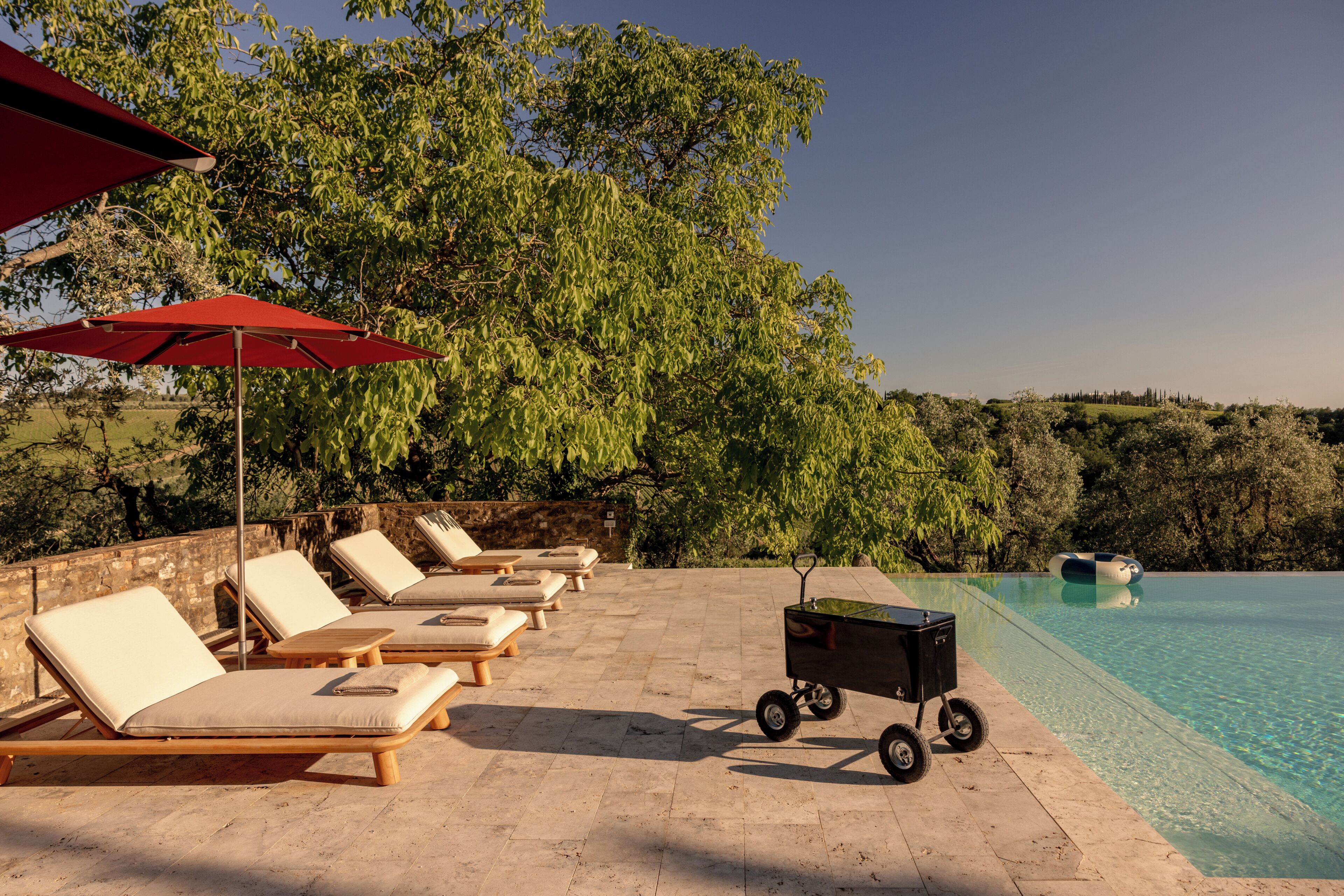 Un espace aménagé au bord de la piscine, avec des chaises longues et une piscine.