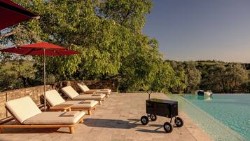 Un espace aménagé au bord de la piscine, avec des chaises longues et une piscine.
