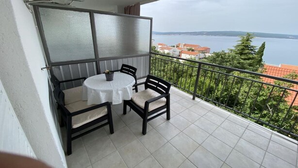 A balcony with a table and chairs, a view of a body of water, and a railing. - Duga House Apartment A3 (Crikvenica)