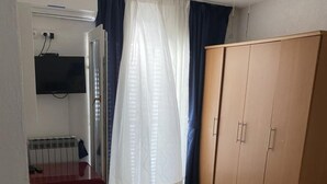 A room with a wooden wardrobe, a red table, and a white curtain. - Duga House Apartment A3 (Crikvenica)