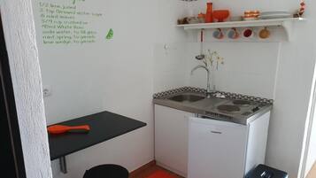 Een koffiezetapparaat/waterkoker, een koelkast, een magnetron, een oven