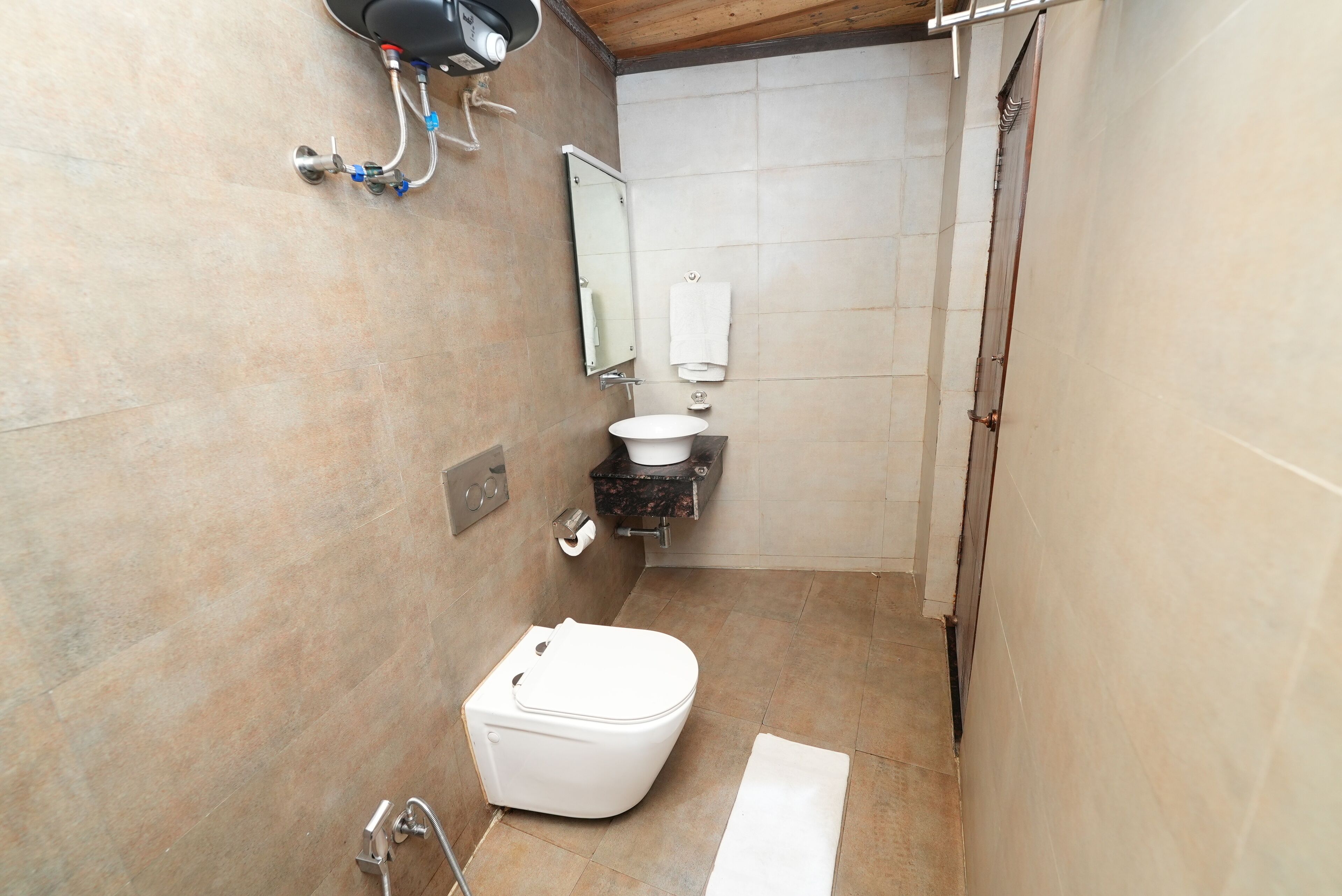 A small bathroom with a toilet, sink, and mirror.