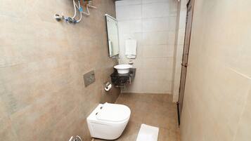 A small bathroom with a toilet, sink, and mirror.