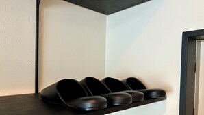 A black shelf with four black slippers. - Corpo SKR (Musashino)