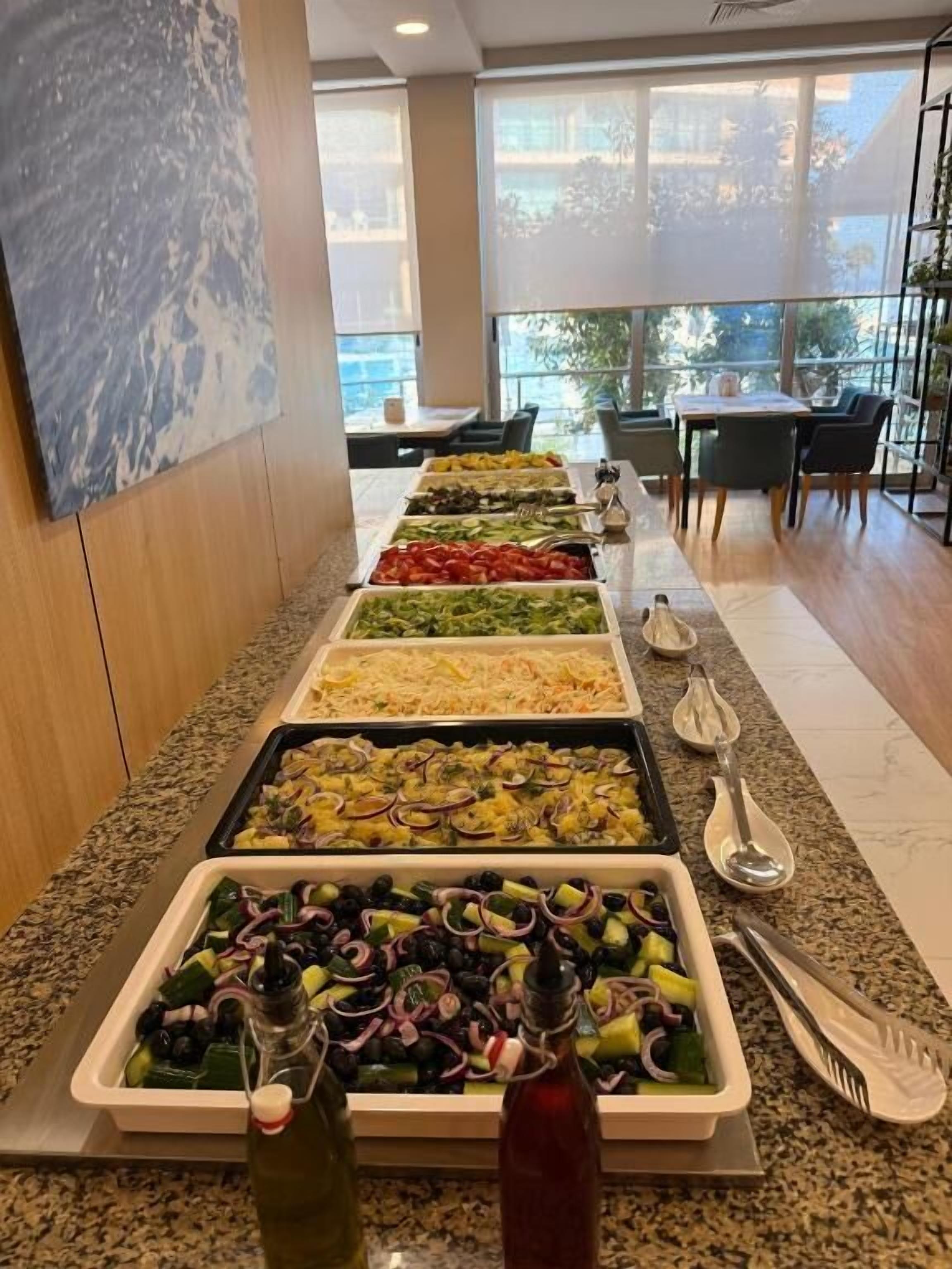 A buffet with various dishes and condiments.